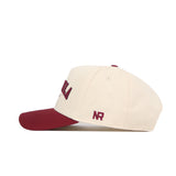 The Missoula Hometown Hat by No Rivals is a cream-colored, structured-fit cotton snapback with a maroon brim and maroon NR initials embroidered on the side.