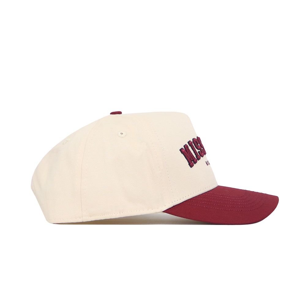 The No Rivals Missoula Hometown Hat features a cream structured fit, burgundy brim, embroidered front text, and premium cotton construction, shown in a side view on a white background.