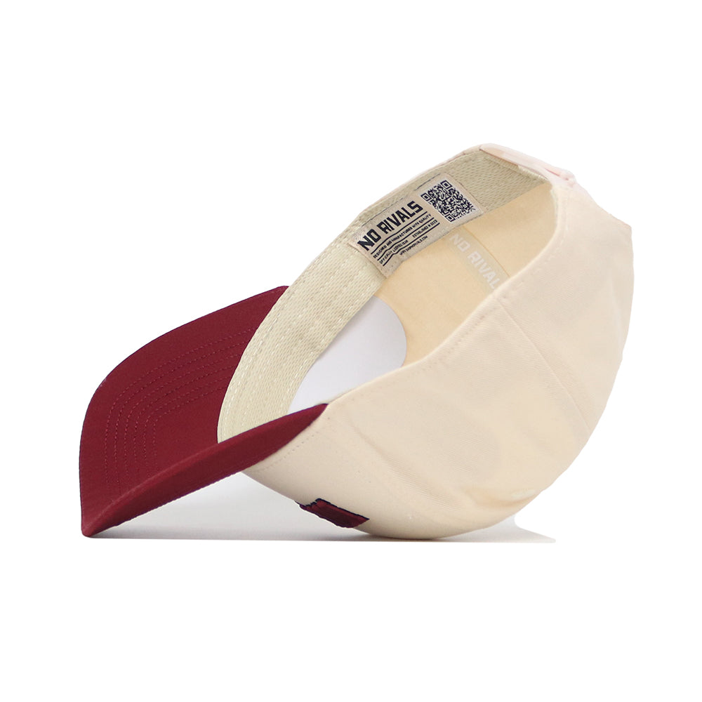 The Missoula Hometown Hat by No Rivals features a cream-colored snapback design with a maroon brim, shown angled to reveal the inside and signature NO RIVALS label. Made from high quality cotton for lasting comfort and durability.