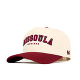 The Missoula Hometown Hat by No Rivals is a cream high-quality cotton cap with a maroon brim. It features “MISSOULA” in large maroon letters, “MONTANA” below, and a small NR logo on the side.
