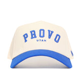 The No Rivals Provo Hometown Hat is a structured white cotton baseball cap with a blue brim, featuring "PROVO" in large blue letters above "UTAH" in smaller blue letters on the front for a comfortable hometown look.