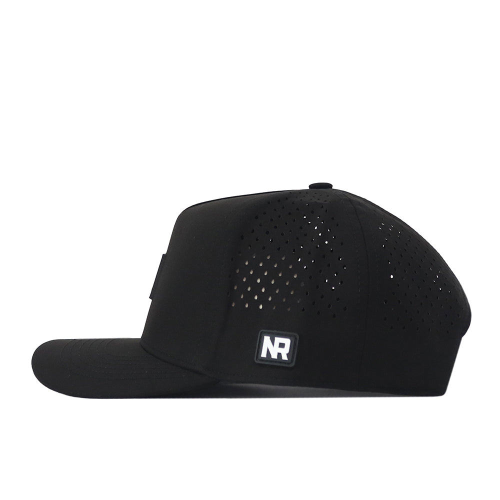 Side view of the Miami Hurricanes Trainer Hat by No Rivals, featuring small ventilation holes on the crown and a rectangular No Rivals logo patch on the lower side panel. Made from high-quality cotton, this snapback provides a comfortable and structured fit.
