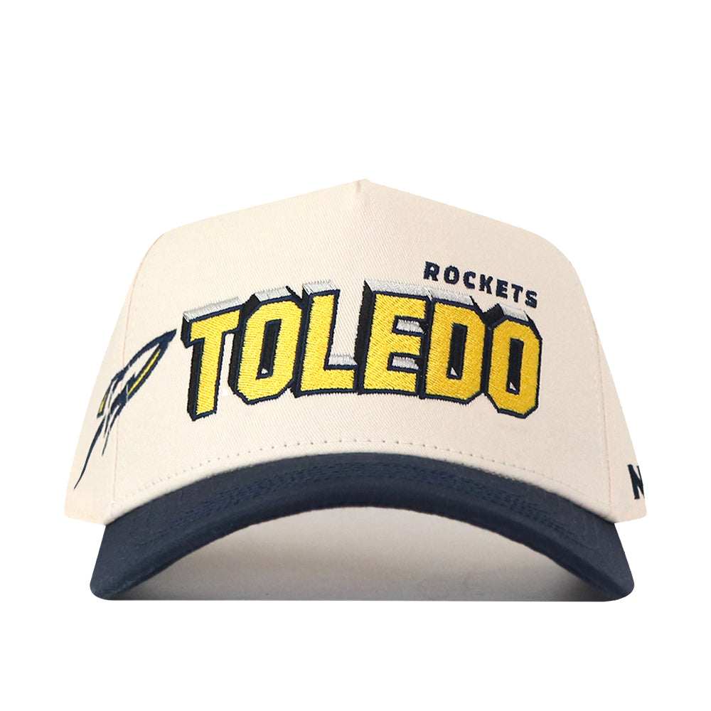 Introducing the No Rivals Toledo Alma Mater Hat—a white and navy cap featuring officially licensed embroidered Toledo Rockets logos for an authentic look, bold yellow and black “TOLEDO ROCKETS” lettering on the front, and a small rocket graphic on the side.
