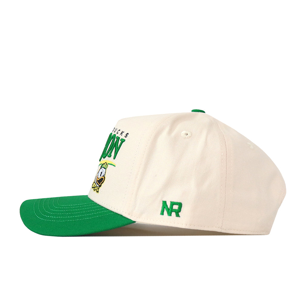 The Oregon Ducks Stride Hat by No Rivals is a white snapback baseball cap featuring a green brim, a green top button, and green “NR” lettering on the side. Crafted from high-quality cotton for lasting comfort and featuring a structured fit, the front showcases partial text alongside a small cartoon duck logo.