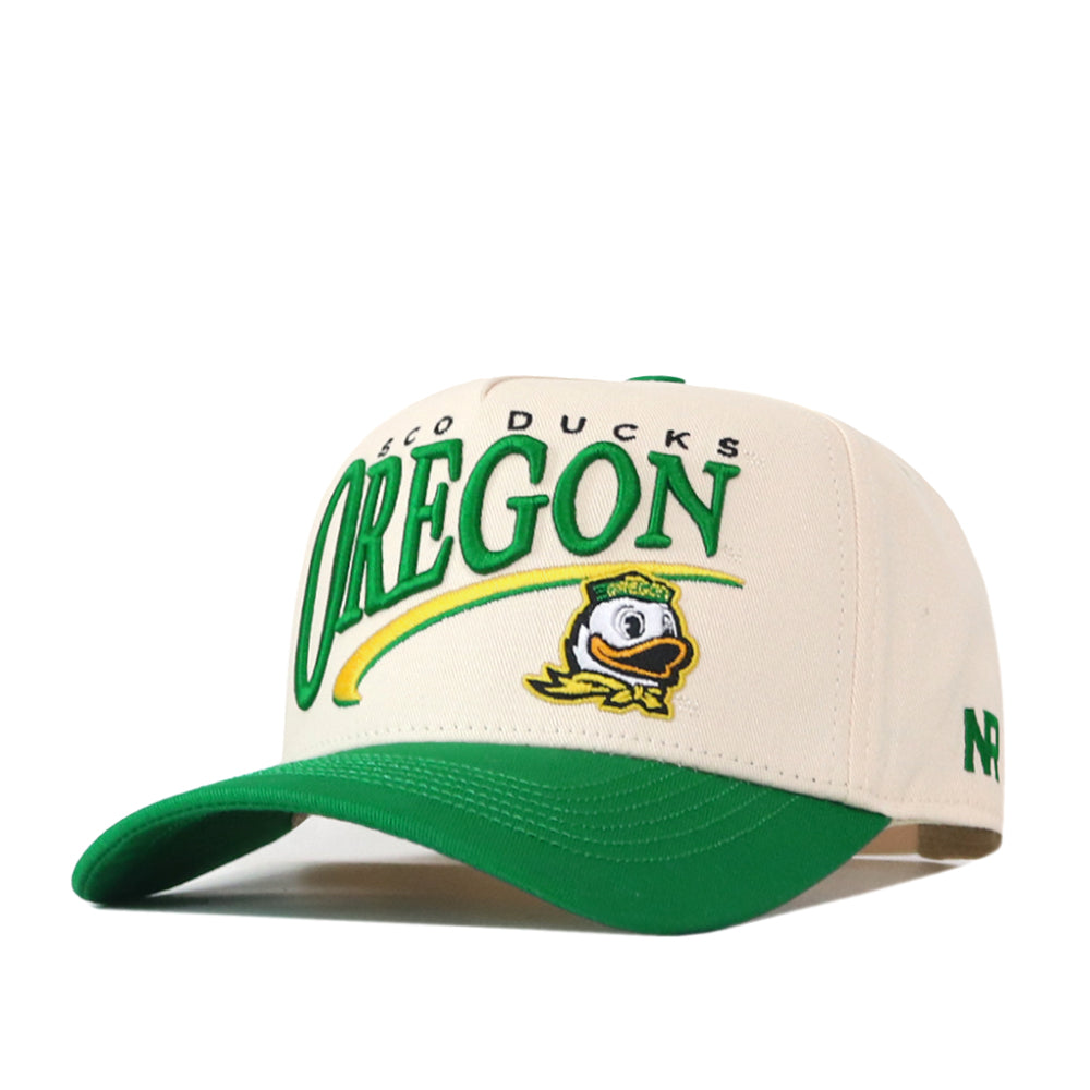 Introducing the Oregon Ducks Stride Hat by No Rivals—a white and green snapback featuring “Oregon,” the Oregon Ducks name, and a cartoon duck logo on the front. The structured fit hat offers a green brim, embroidered NR logo on the side, and is crafted from high quality cotton for lasting comfort.