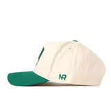 A side view of the North Dakota State Bison Stadium Hat by No Rivals, featuring a cream-colored crown and a green bill. Green embroidered “NR” lettering is stitched near the back.