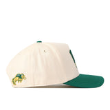 The No Rivals North Dakota State Bison Stadium Hat is a cream-colored snapback with a green brim, displayed in side profile. Near the back on the side, it features an embroidered green and yellow bison logo.