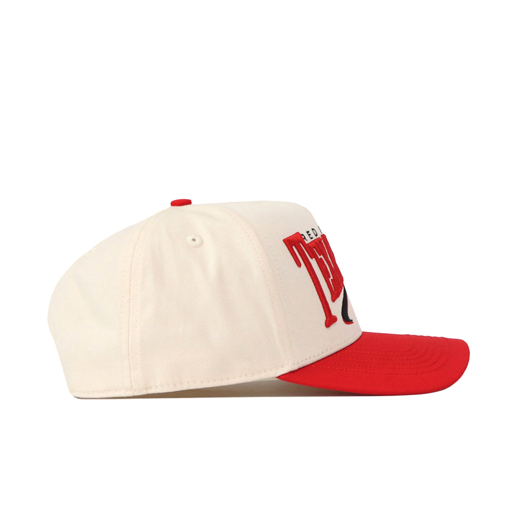 The No Rivals Texas Tech Red Raiders Stride Hat is a cream-colored snapback with a red brim and red embroidered logos on the front, shown from the side.
