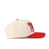The No Rivals Texas Tech Red Raiders Stride Hat is a cream-colored snapback with a red brim and red embroidered logos on the front, shown from the side.