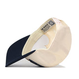 The No Rivals Georgia Tech STRIDE Hat features a two-toned design, with a navy blue brim and a cream crown. Shown from the underside, it reveals inner tags, detailed stitching, and subtly embroidered Georgia Tech logos—making it the perfect finishing touch for your gameday fit.