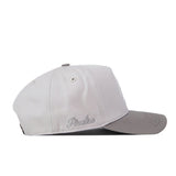 Side view of the No Rivals ECU Pirates Graphite Hat, a gray snapback baseball cap featuring "Pirates" embroidered in cursive near the back. This hat includes an embroidered logo, flat brim, and ventilation eyelets on the crown—making it the perfect gameday fit.