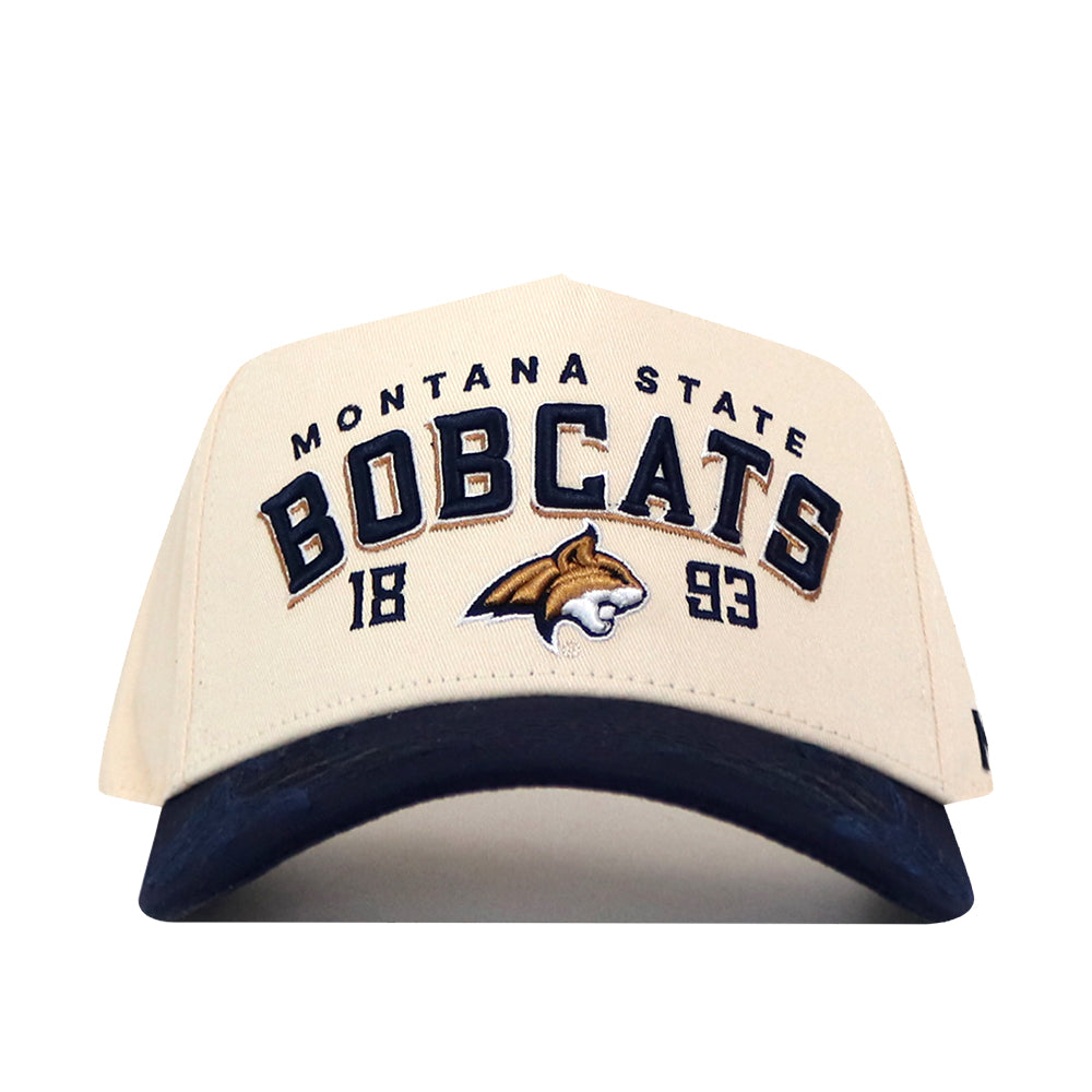 The No Rivals Montana State Rally Hat is a beige snapback featuring a blue brim. “Montana State Bobcats” and “1893” are embroidered on the front, along with an officially licensed bobcat logo at the center.
