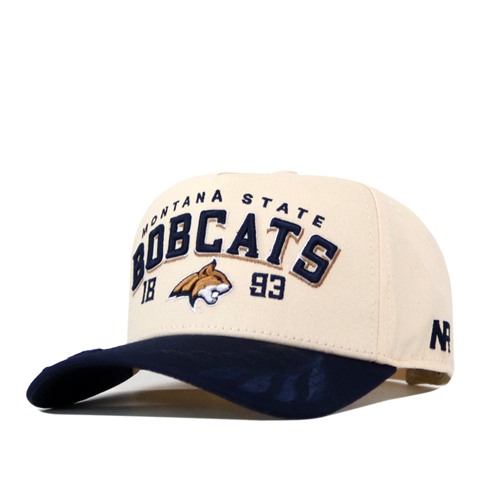 The No Rivals Montana State Rally Hat is a beige and navy snapback featuring “Montana State Bobcats 1893” and an embroidered bobcat logo on the front—an officially licensed accessory for true fans.