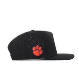 Showcased from a side profile against a white background, the No Rivals Clemson Golf Hat - Swinging in black features a flat brim, perforated side panels, and an orange embroidered paw print logo on the side—perfect for finishing your gameday look.