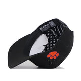A black Clemson Golf Hat - Swinging by No Rivals, featuring an orange embroidered paw print logo, is displayed from an angled underside view. Ideal for your gameday look, the inner band shows the words "NO RIVALS." This snapback hat also includes a black mesh lining with white dots on the inside.
