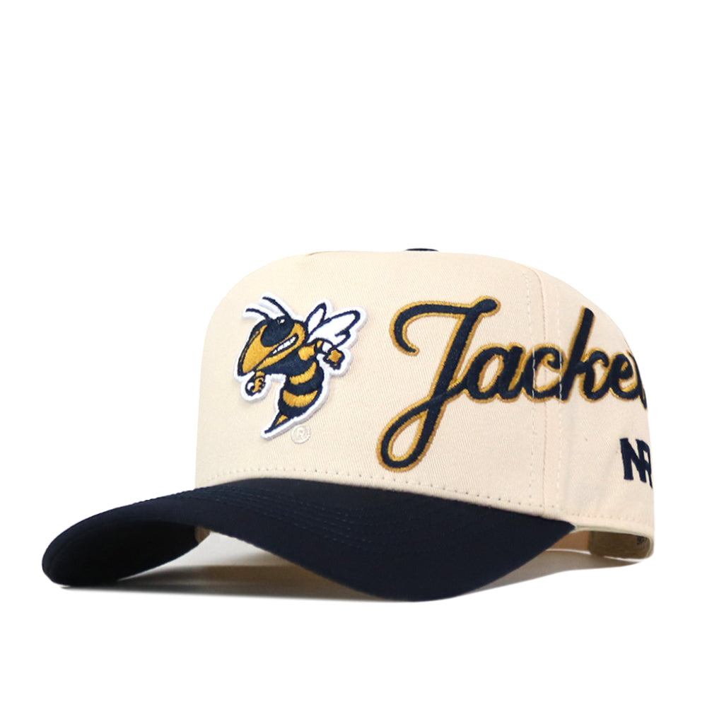 Georgia Tech Yellow Jackets Halftime Hat by No Rivals features “Jackets” in script, an embroidered yellow jacket mascot patch, a dark navy bill, and the letters “NF” stitched on the side. This officially licensed snapback cap has a cream crown.