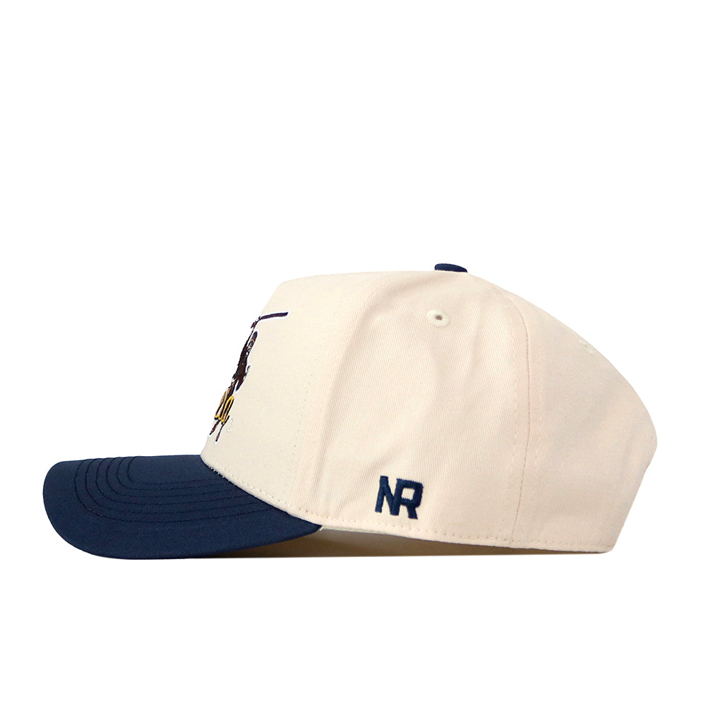 A white No Rivals WVU Mountaineers Script Overlay Mascot Patch Hat featuring a navy blue brim and a stitched NR logo on the side. The front displays a partially embroidered design in dark blue and yellow, along with an officially licensed embroidered WVU logo for added authenticity.