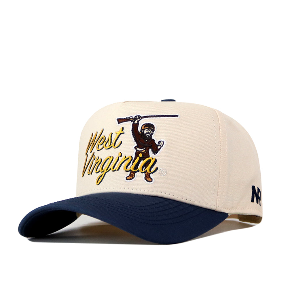 The No Rivals WVU Mountaineers Script Overlay Mascot Patch Hat is a beige and navy baseball cap featuring “West Virginia” in yellow script and a mountaineer holding a rifle. This officially licensed hat includes an embroidered logo, a navy N logo on the side, and an adjustable snap back closure for the perfect fit.