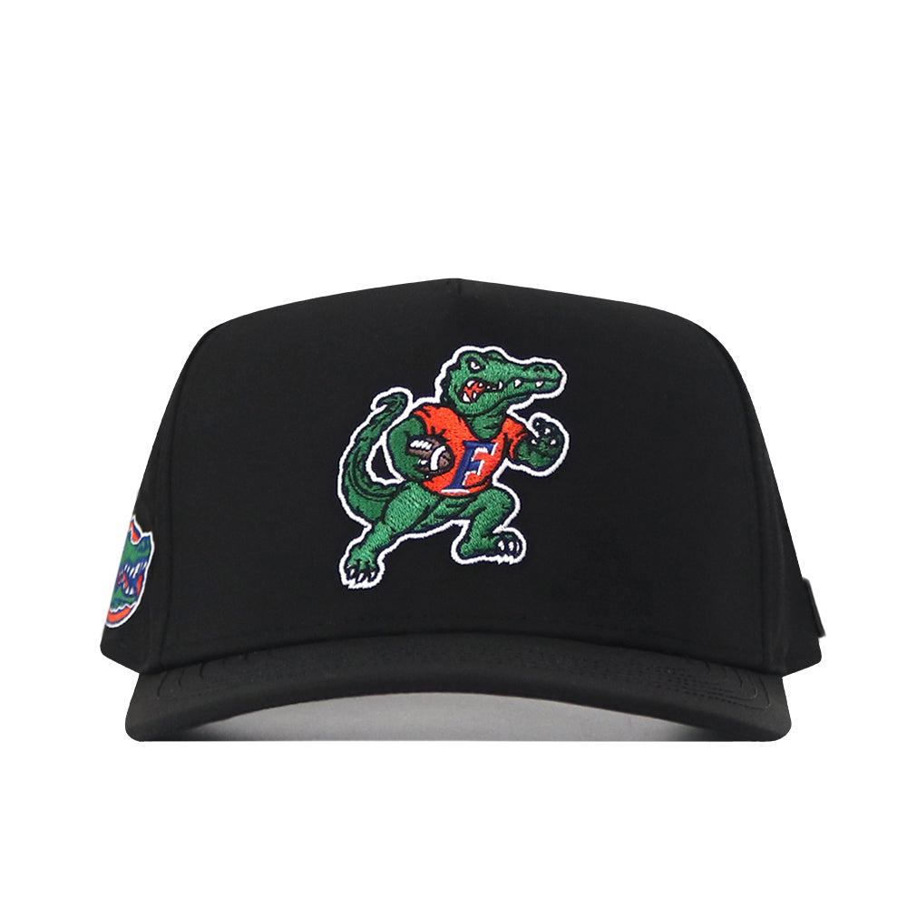 The No Rivals Florida Gators Football Mascot Hat in black features an embroidered alligator mascot wearing an orange jersey and holding a football, along with a small colorful patch on the left side. Crafted from high-quality performance fabric, this hat is finished with a snapback closure for a comfortable and customizable fit.