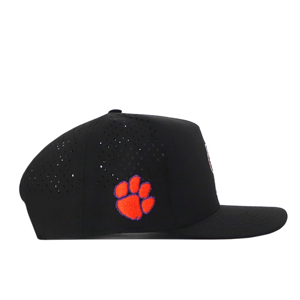 The Clemson Tigers Football Mascot Hat - Black by No Rivals is shown in a left-facing side view. Crafted from performance fabric, this black baseball cap features small ventilation holes for breathability, an orange embroidered paw print logo on the side, and a convenient snap back adjustment for a personalized fit.