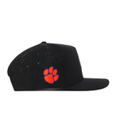 The Clemson Tigers Football Mascot Hat - Black by No Rivals is shown in a left-facing side view. Crafted from performance fabric, this black baseball cap features small ventilation holes for breathability, an orange embroidered paw print logo on the side, and a convenient snap back adjustment for a personalized fit.