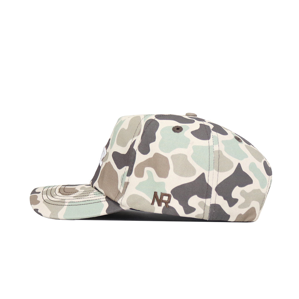 The No Rivals Iowa State Huntsman Hat is a 5-panel duck camo cap in green, beige, and brown, shown from the side. "NR" is embroidered in brown near the back for a rugged, stylish finish.