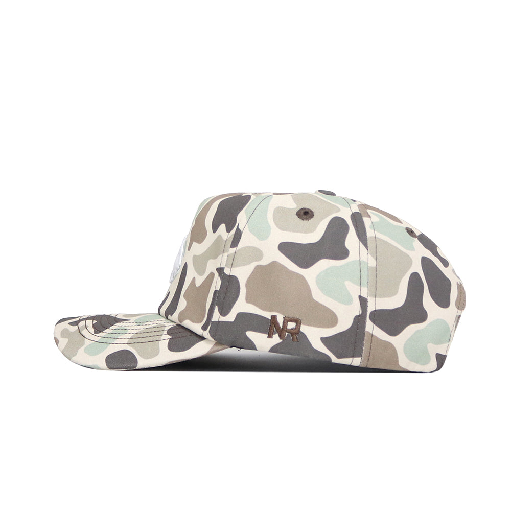 Side view of the Montana State Huntsman Hat by No Rivals, showcasing green, beige, and black camo. This 5-panel cap features “NR” embroidered in dark thread near the back.