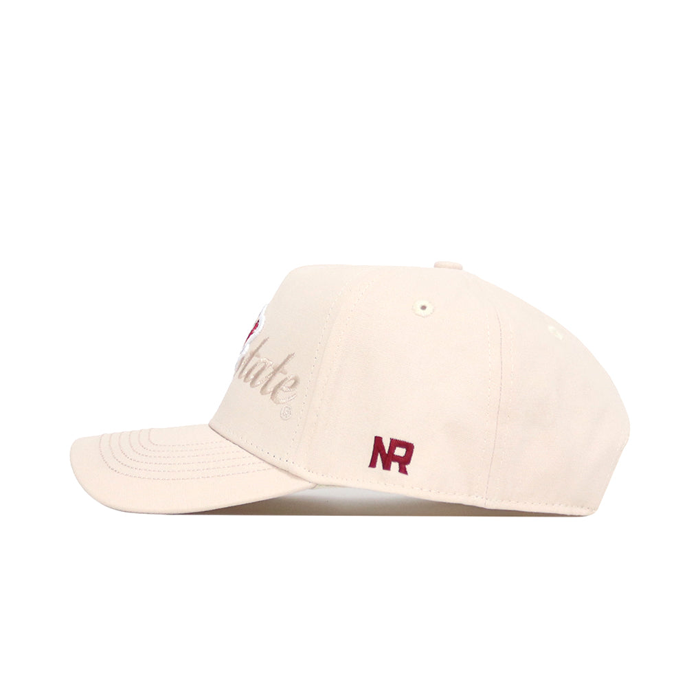The Iowa State Stacked Hat by No Rivals is a beige cotton snapback with a curved brim and dark red "NR" embroidered near the back. Subtle stitching details are visible in the cap's profile, shown against a white background.