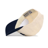 The Reno Hometown Hat by No Rivals is shown from below, featuring a cream cotton crown, navy blue brim, structured fit, white sweatband, and a NO RIVALS label inside the crown.