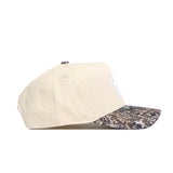 Side view of the No Rivals USF Camo Connector Hat in beige, featuring a camouflage brim, two side ventilation eyelets, and a classic snapback closure.