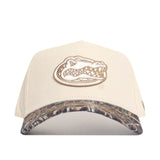 The No Rivals Florida Camo Connector Hat is a beige baseball cap with an embroidered alligator head logo, a camouflage pre-curved brim, and an adjustable snap back for comfort.