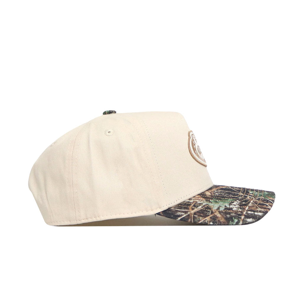 The No Rivals Florida Camo Connector Hat is a beige baseball cap with a camo-patterned pre-curved brim, side view, featuring an embroidered front logo and a snapback closure for a comfortable, structured fit.