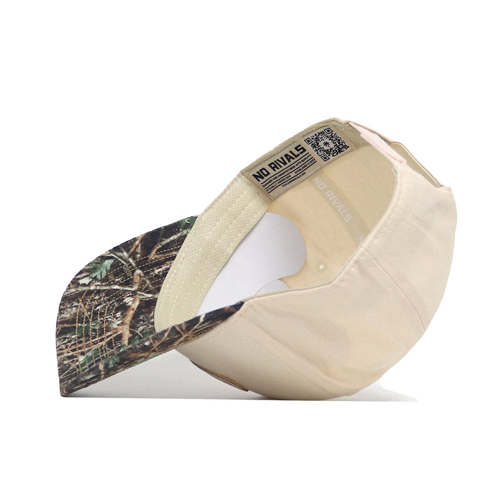 The Florida Camo Connector Hat by No Rivals is shown upside down, revealing the inside label with the brand name and a visible QR code. It features a structured fit and a camouflage-patterned pre-curved brim.
