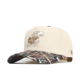 The No Rivals Kansas Camo Connector Hat features a beige crown, camo-patterned brim, and embroidered KU Jayhawk logo. Made from high-quality cotton with a structured fit and adjustable snapback closure for comfort.