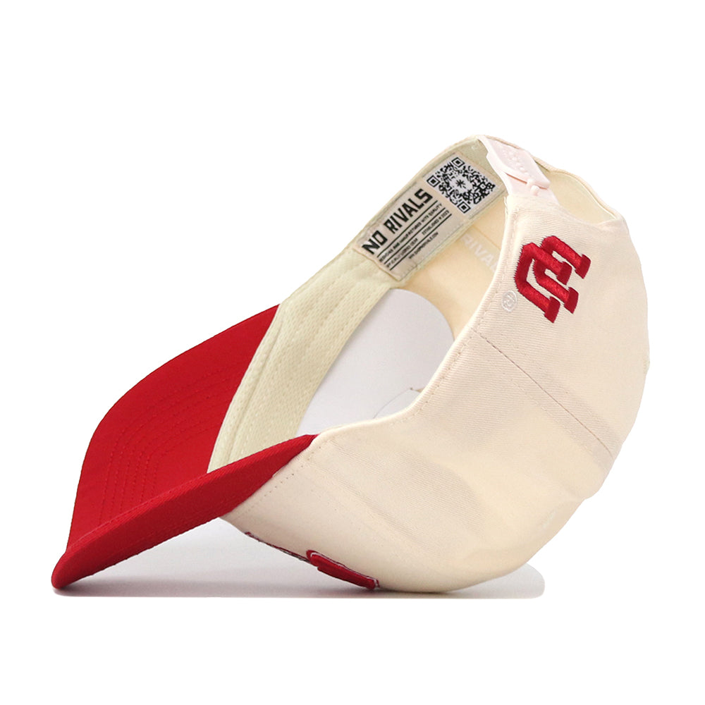 The Utah Utes Stadium Hat by No Rivals is displayed upside down, showcasing its red brim and cream crown. Inside, a NO RIVALS label and QR code are visible. The back of this officially licensed snapback features bold red embroidered logos.
