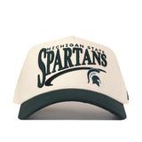 The Michigan State Spartans Stride Hat by No Rivals is a white and green snapback cap featuring an embroidered Michigan State Spartans name and Spartan helmet logo on the front, crafted from high-quality cotton for a comfortable, structured fit.