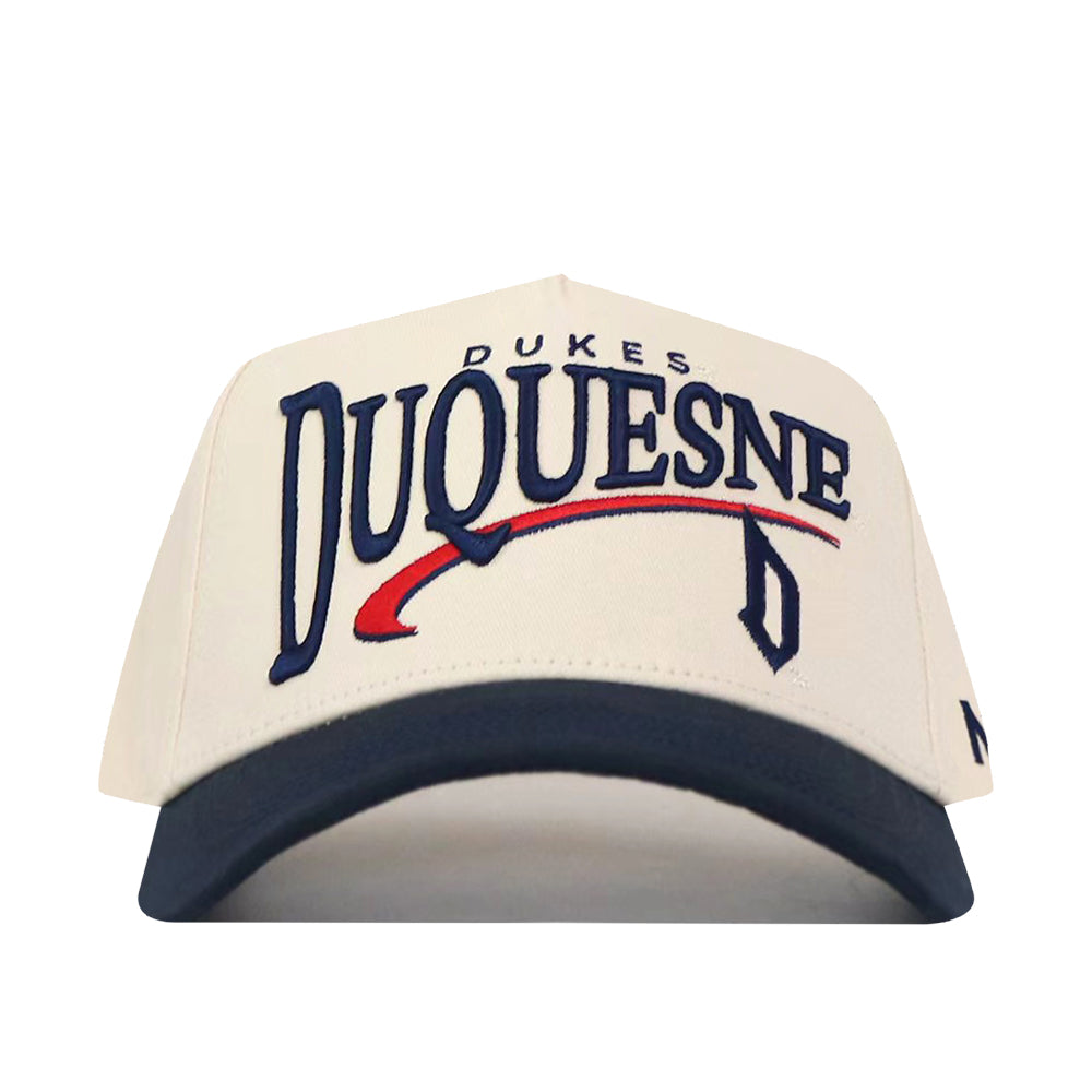 Introducing the No Rivals Duquesne Stride Hat—a white snapback baseball cap with a navy blue brim, featuring officially licensed embroidered DUQUESNE DUKES logos in bold blue and red lettering on the front. It’s the perfect way to show your team pride.