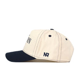 A side view of the Auburn Tigers Vintage Hat by No Rivals, featuring a beige crown with a black brim and black stitching. This officially licensed snapback cap showcases an embroidered NR logo near the back for a distinctive look.