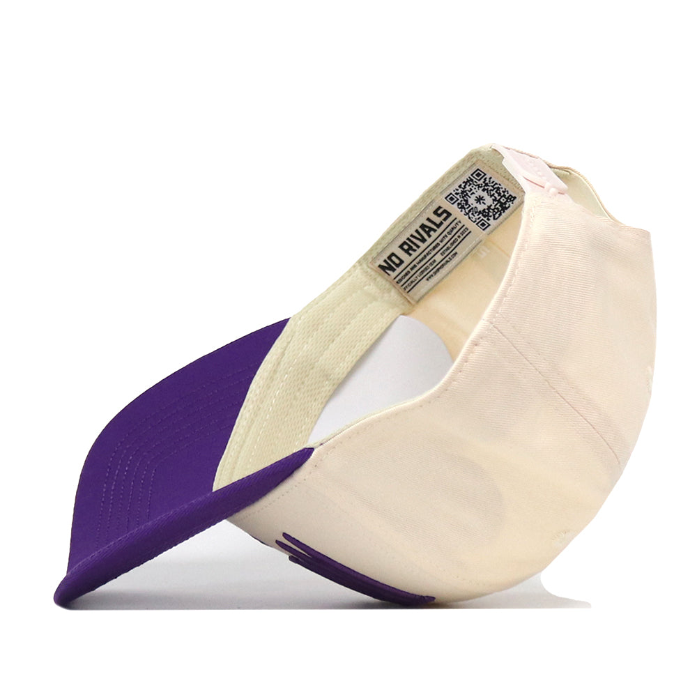 A cream and purple Kansas State Wildcats Stride Hat by No Rivals is displayed on its side, showcasing the vibrant purple underside of the brim and an inside tag with the brand’s NO RIVALS logo alongside a QR code. Perfect for your gameday fit, this snapback cap features bold embroidered Kansas State logos for a standout look.