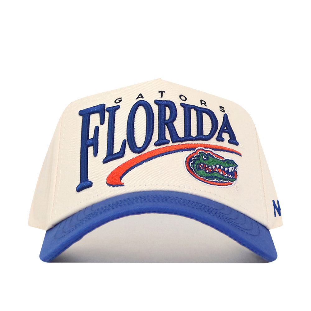 Introducing the Florida Gators Stride Hat by No Rivals—a stylish white and blue baseball cap featuring “Gators Florida” and the University of Florida Gators logo embroidered on the front. Designed with a structured fit for a classic look and an adjustable snapback closure for customizable comfort, this hat is crafted from high-quality cotton material to ensure durability and lasting style.
