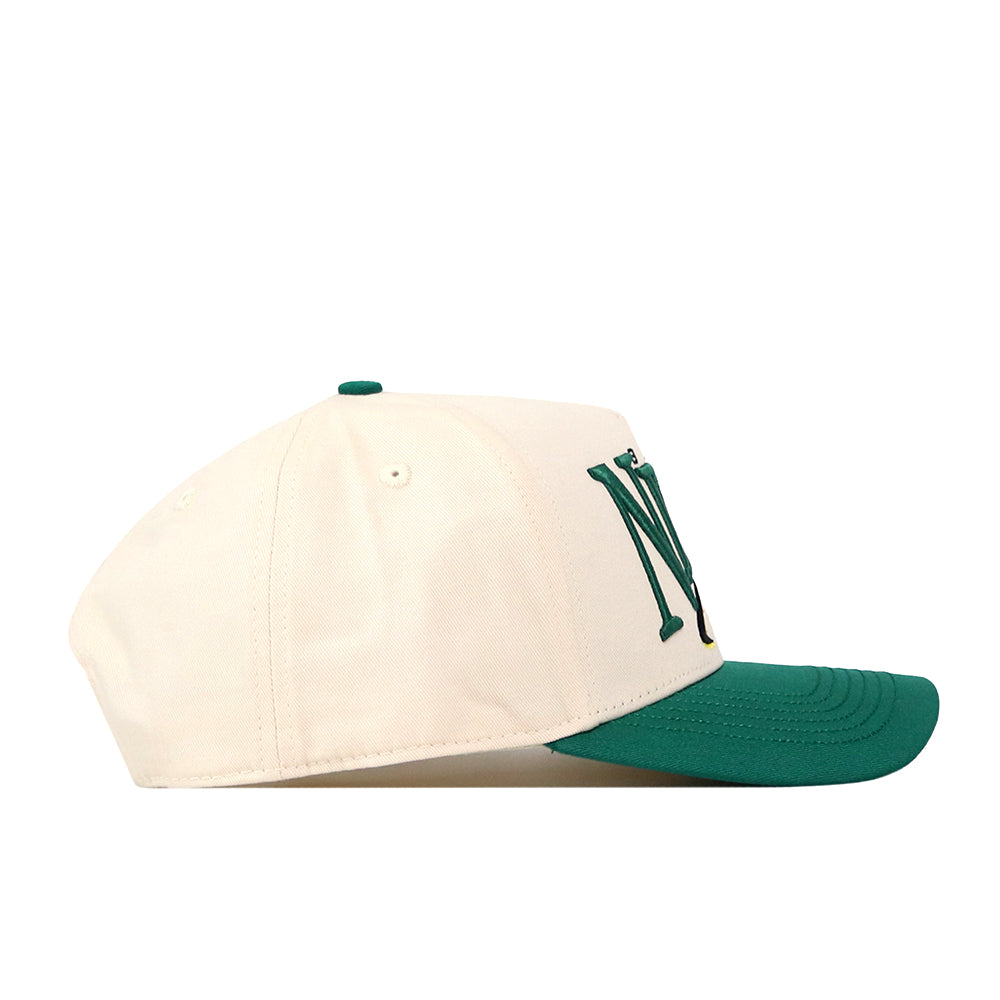 The North Dakota State Bison Stride Hat by No Rivals features a cream snapback design with a green brim and a bold dark green embroidered N logo on the side, shown in profile against a white background—the perfect finishing touch for your next gameday fit.