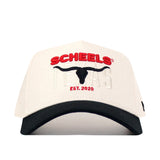 The Scheels Longhorn Hat - Black is a white snapback cap with a black brim, featuring embroidered SCHEELS in red, TEXAS in white, a black longhorn silhouette, and EST. 2020 in red on quality cotton for lasting comfort.