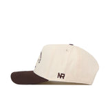 A cream ECU Pirates Outlaw Hat - Classic by No Rivals with a dark brown brim, shown in a side view. The initials "NR" are embroidered in brown thread on the side, adding a distinctive logo to your game day look.