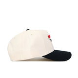 The Scheels Longhorn Hat - Black is a cream baseball cap with a black brim, shown from the side on a white background. Made of high-quality cotton, this structured snapback features red and black embroidery on the front.