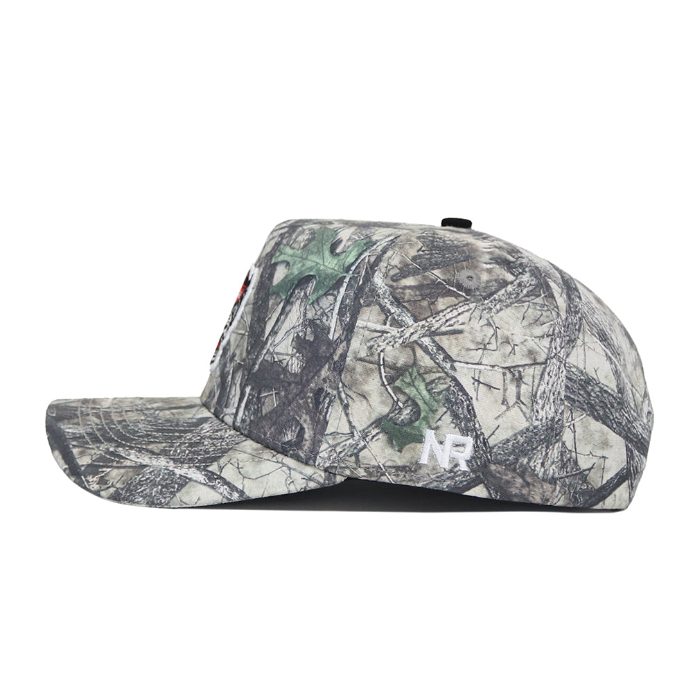 Side view of the NC State Outland Hat by No Rivals, a camouflage snapback with a flat brim and small white NR logo on the back. Made from premium cotton for lasting comfort and style.
