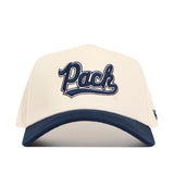 The No Rivals Nevada Logo Patch Hat is a white cap with a navy brim, featuring "Pack" in stylized navy 3D embroidery on the front and a snapback closure.