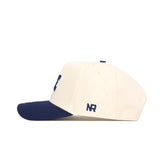 The No Rivals Rice Ballpark Hat is cream-colored with a navy blue brim and embroidered NR logo, shown in profile. It features a snap back adjustment for a perfect fit.