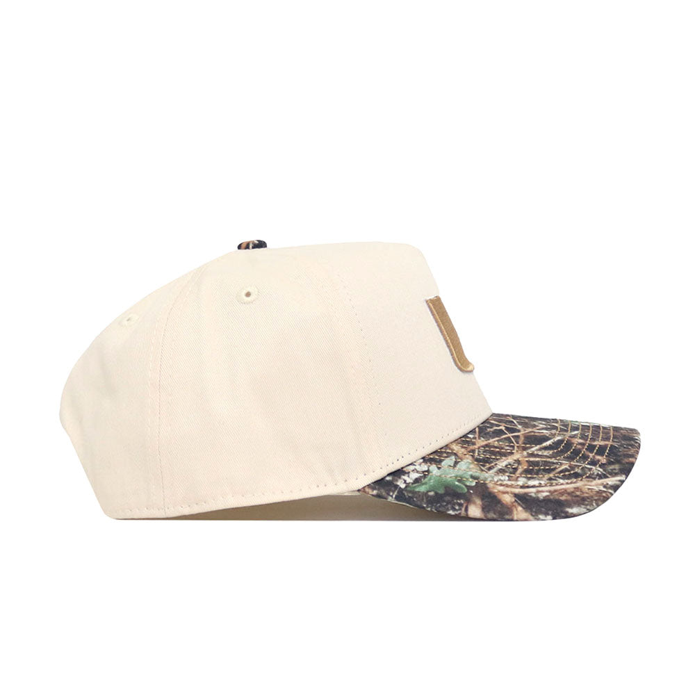 The No Rivals Miami Camo Connector Hat is a beige snapback with a camouflage brim and structured fit, crafted from high-quality cotton. Shown from the side against a white background.