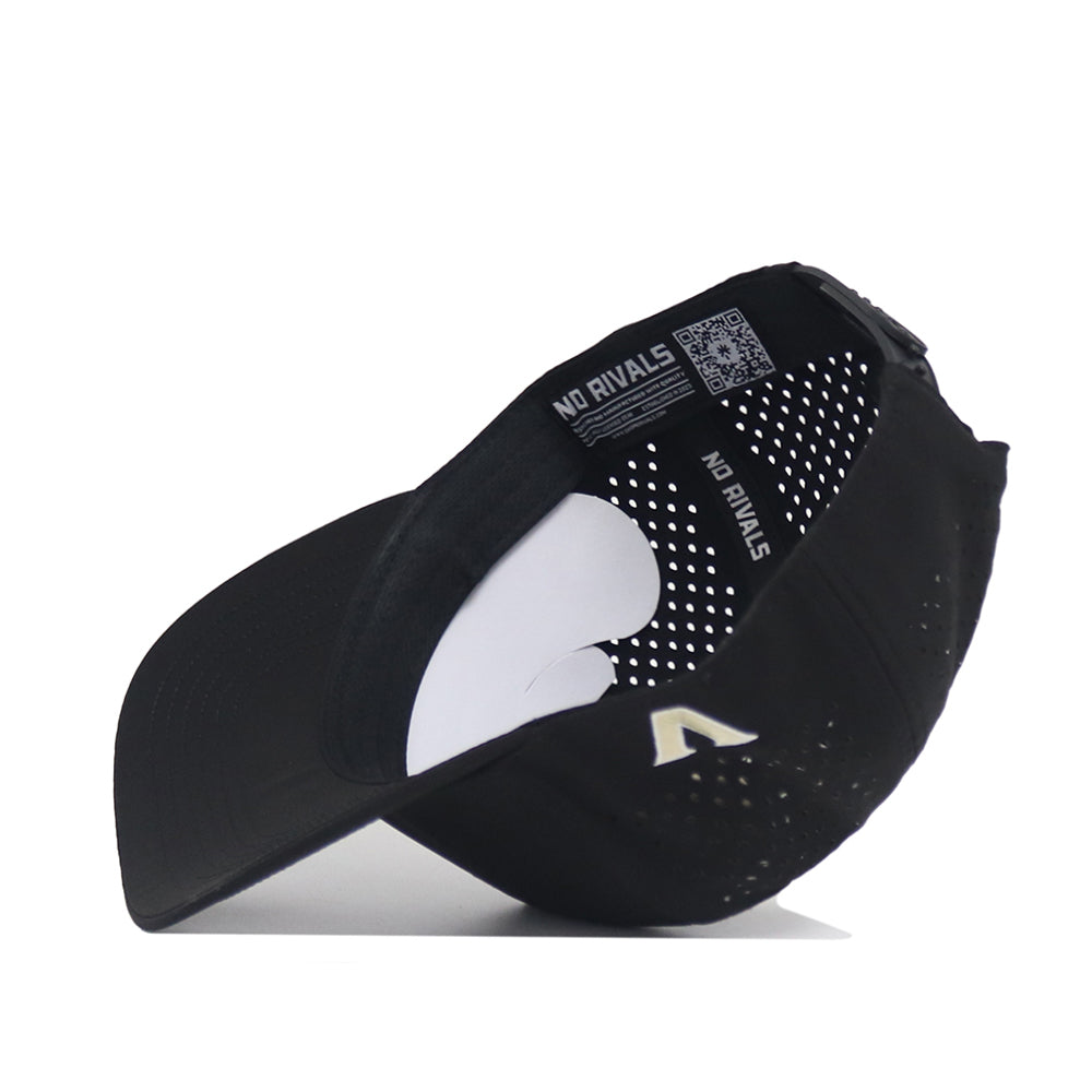 The Vanderbilt Golf Hat - Black by No Rivals is shown upside down, displaying its perforated interior panels, "NO RIVALS" label, and a QR code. The exterior features an embroidered white V logo near the brim.