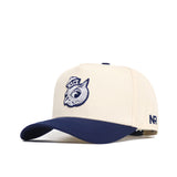 The Rice Sammy Sailor Patch Hat by No Rivals is a cream snapback cap with navy brim, featuring an embroidered owl head and RICE on the front, plus NR stitched on the side.